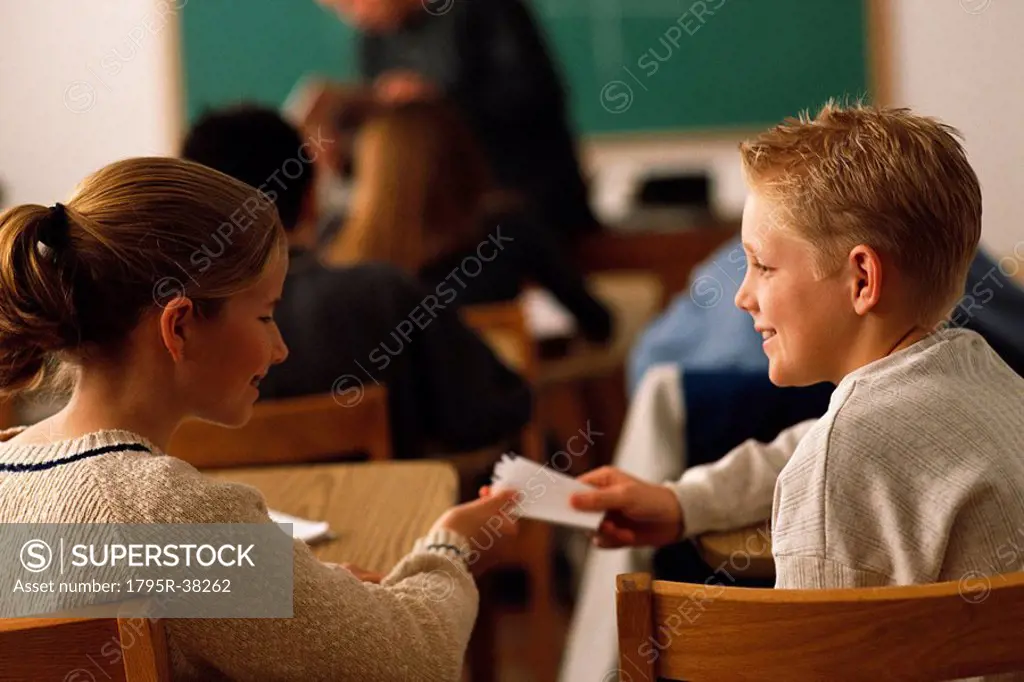 Students passing note in classroom