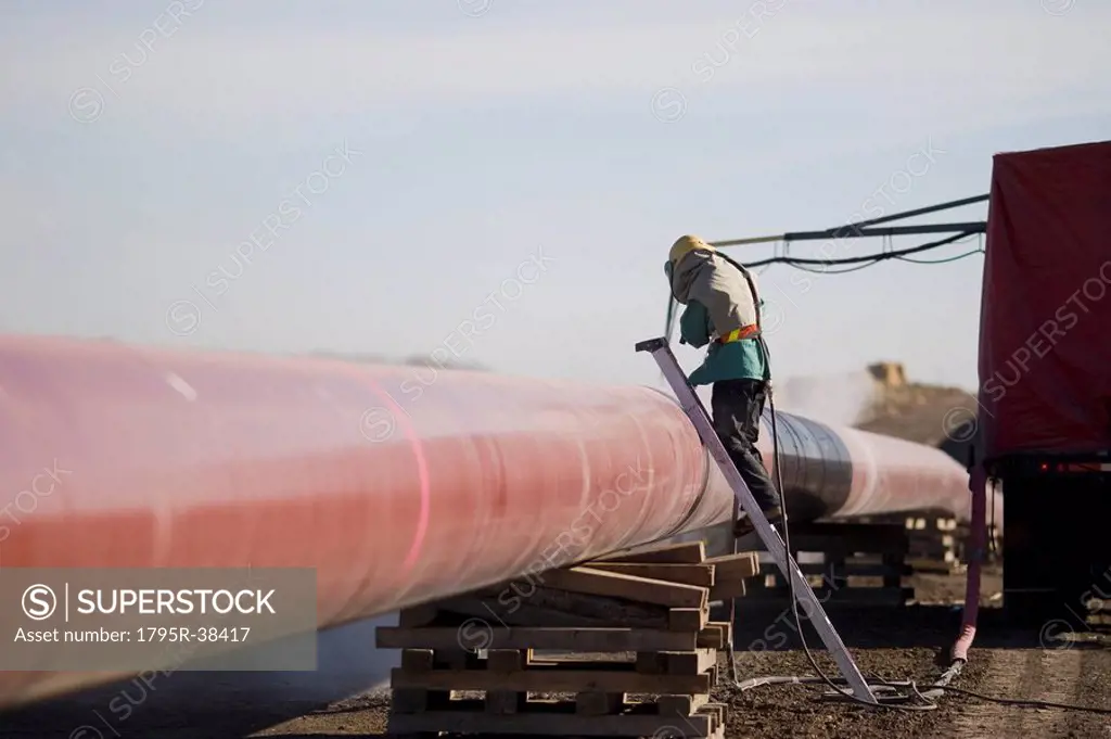 Construction worker cleaning pipeline