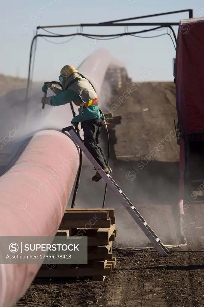 Construction worker cleaning pipeline