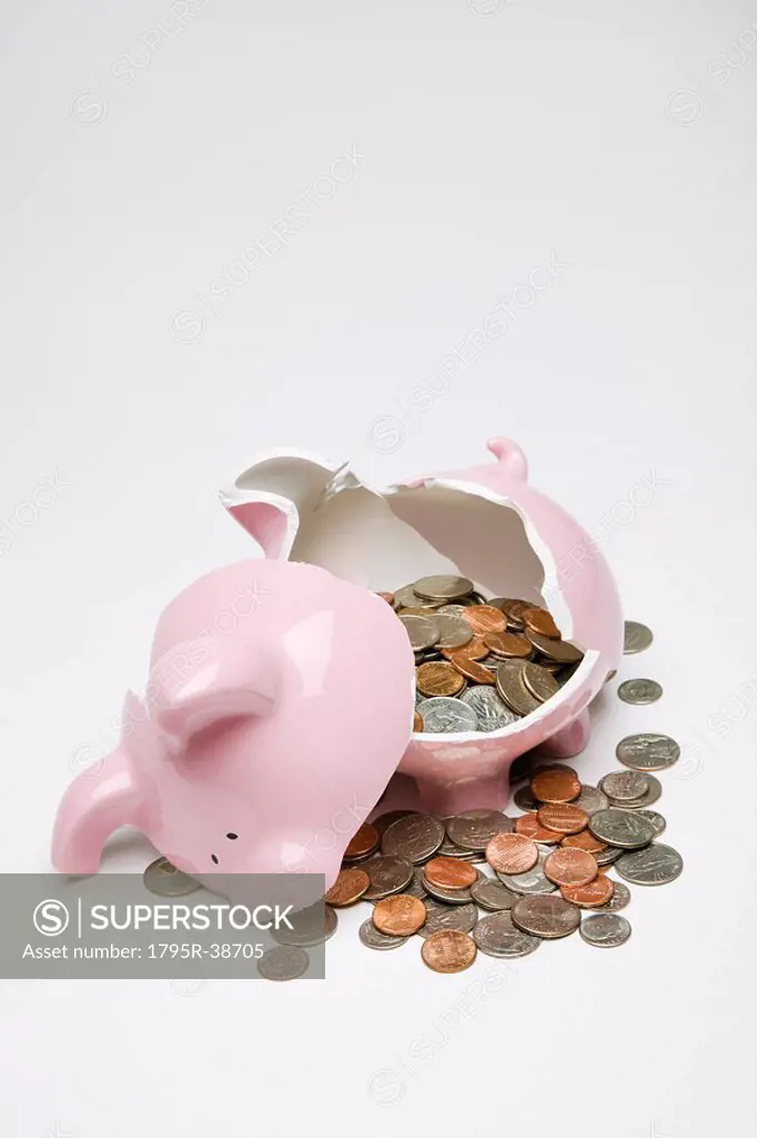 A broken piggy bank with coins