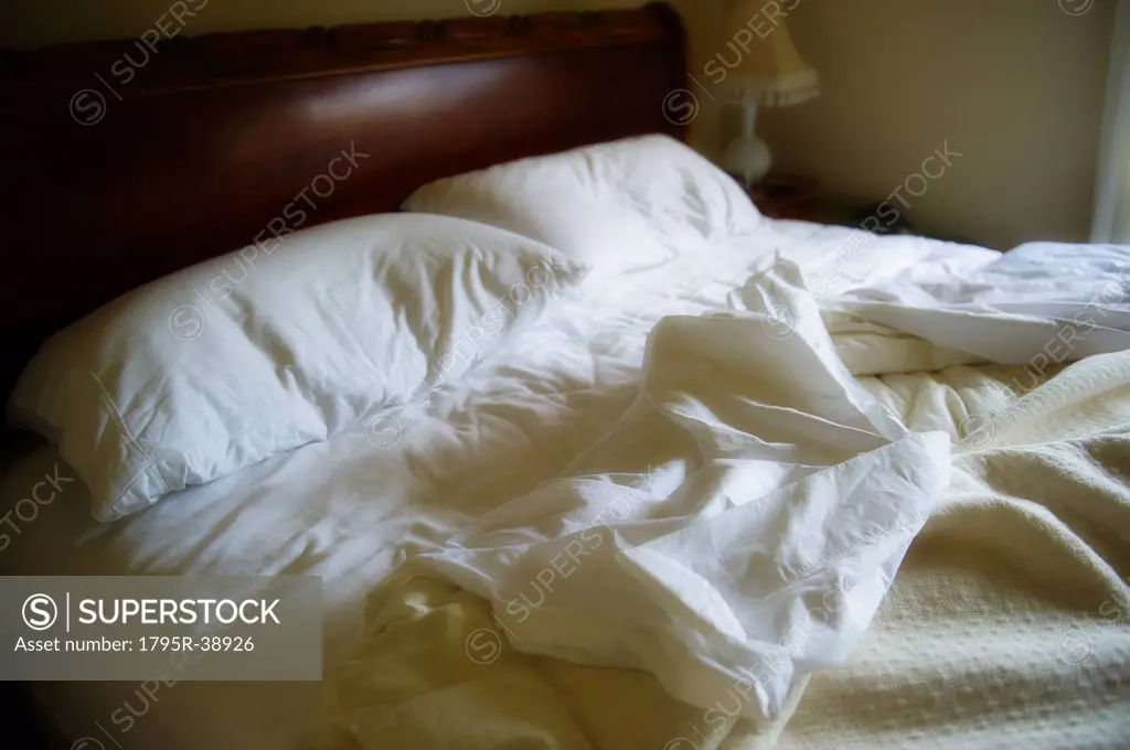 Unmade bed with white duvet