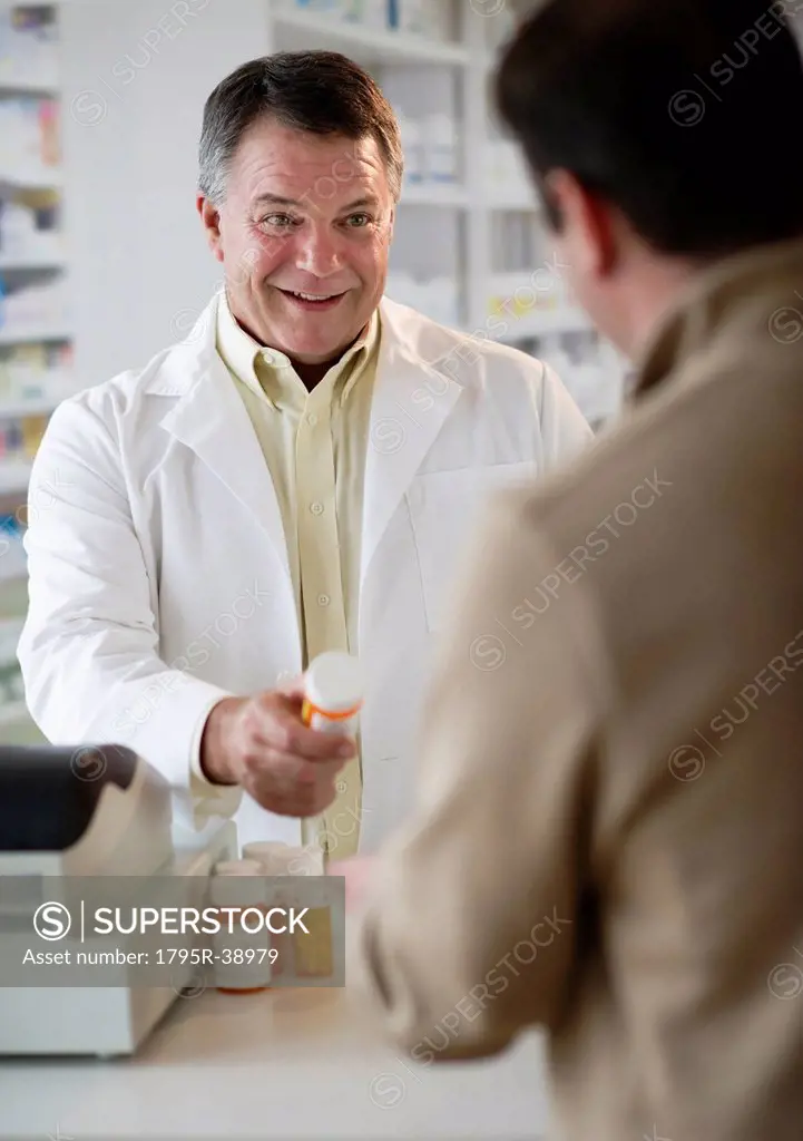 USA, New Jersey, Jersey City, Pharmacist selling medication in pharmacy