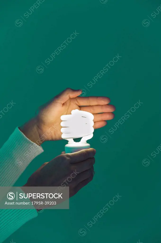Woman´s hands holding energy efficient lightbulb