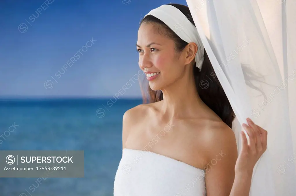 USA, New Jersey, Jersey City, Woman wrapped in towel near sea
