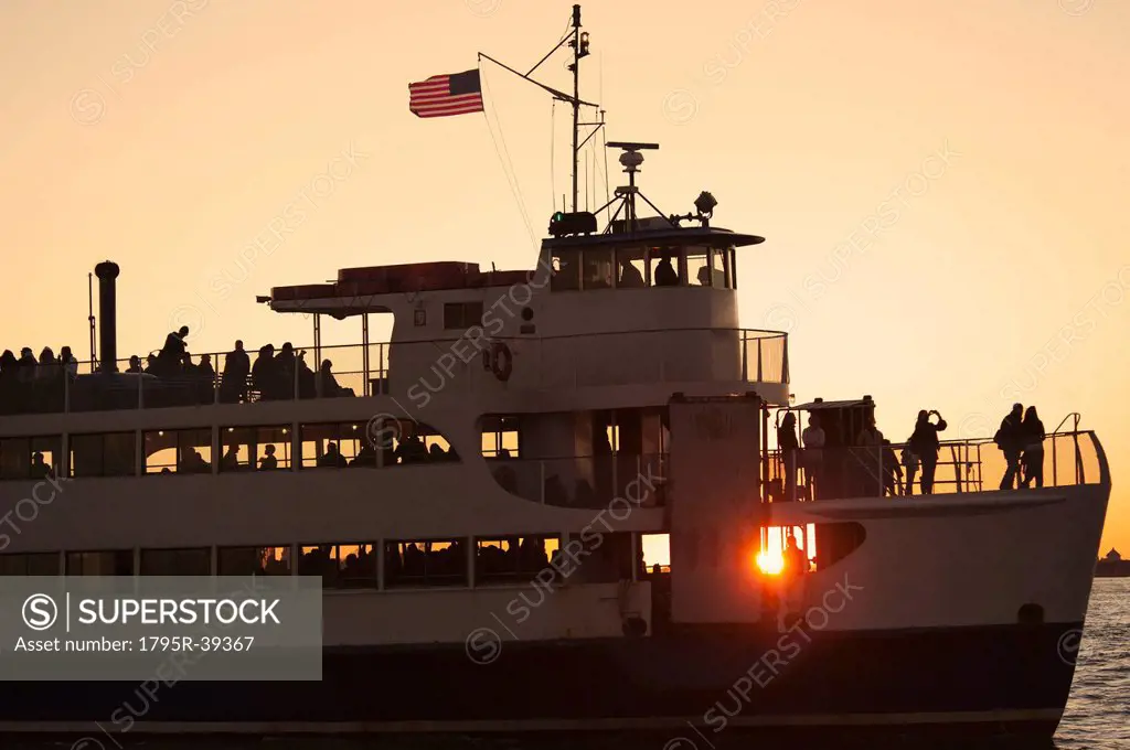 USA, New York City, Silhouette of passengers on tourboat