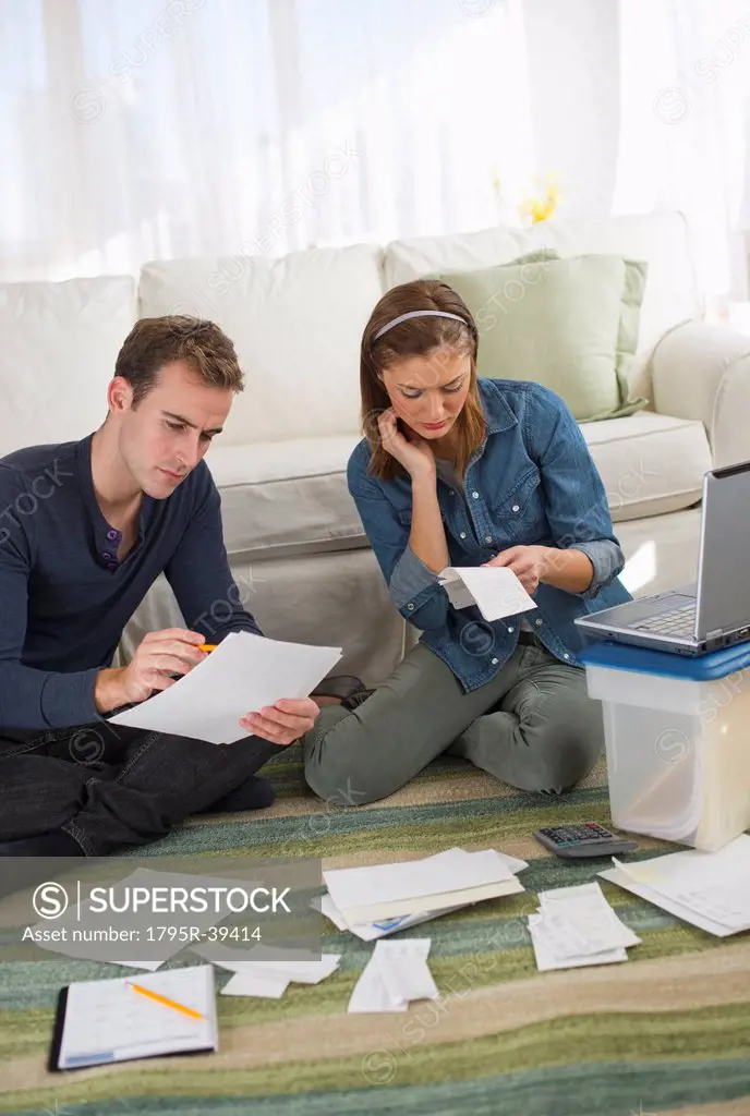 USA, New Jersey, Jersey City, Portrait of young couple doing paperwork at home