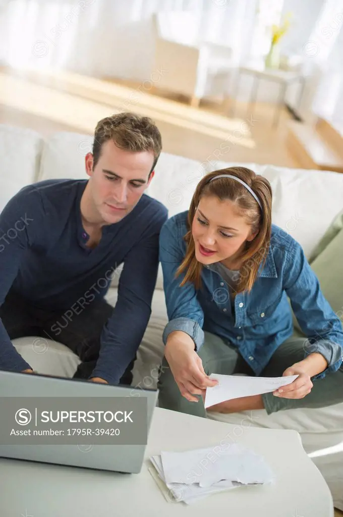 USA, New Jersey, Jersey City, Portrait of young couple doing paperwork at home