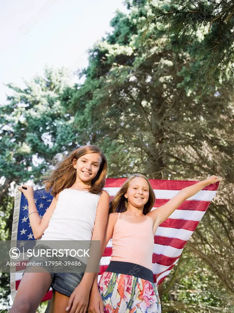 USA, New York, Two girls 10_11, 10_11 playing with American flag