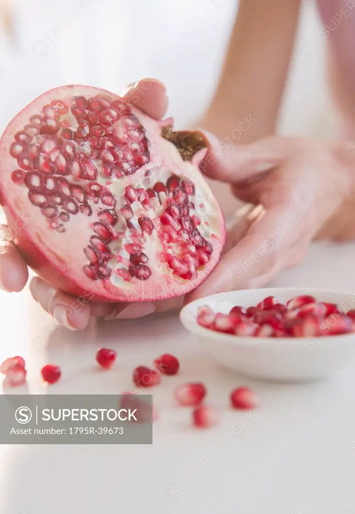 USA, New Jersey, Jersey City, Womans hand with pomegranate cross_section