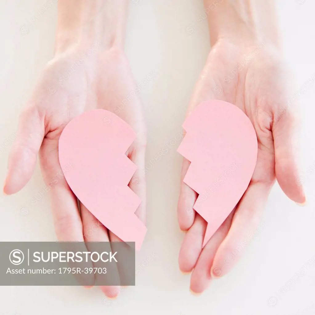 USA, New Jersey, Jersey City, Woman´s hand holding two halves of heart