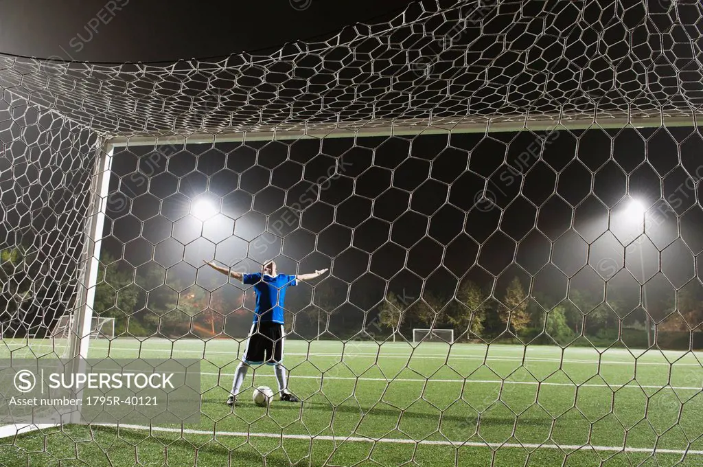 USA, California, Ladera Ranch, goalie on illuminated soccer field at night