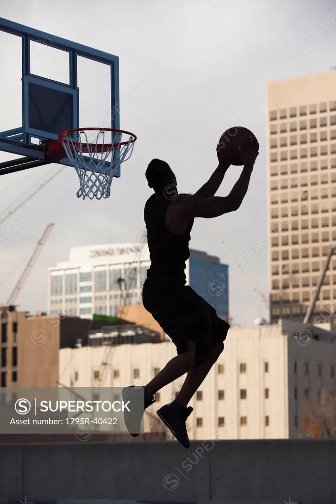USA, Utah, Salt Lake City, Silhouette of young man playing basketball