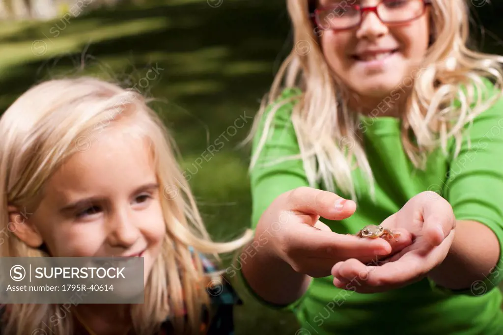 USA, Utah, close up of sisters 6_7, 8_9  holding frog