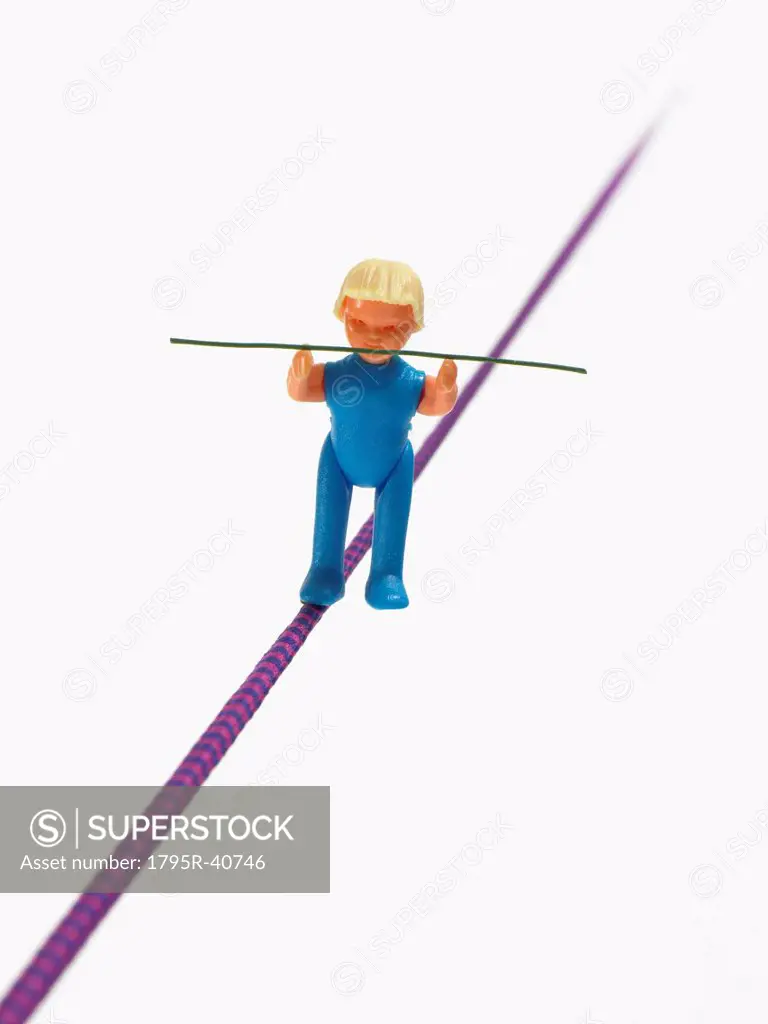 Studio shot of figurine balancing on tightrope