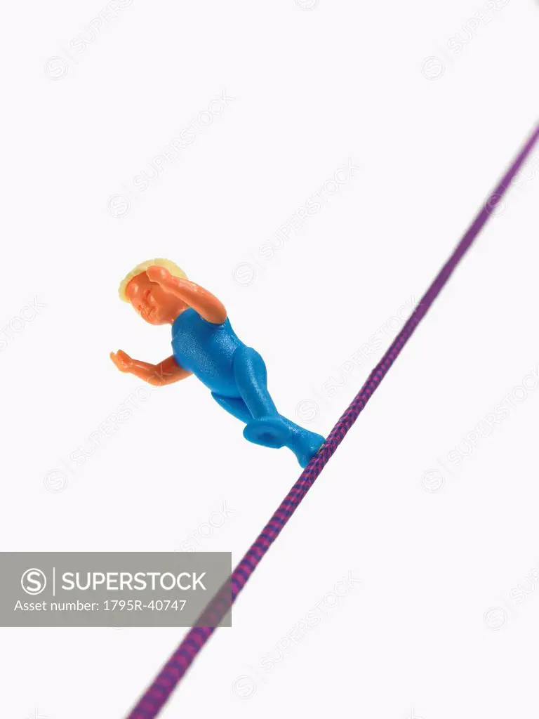 Studio shot of figurine balancing on tightrope