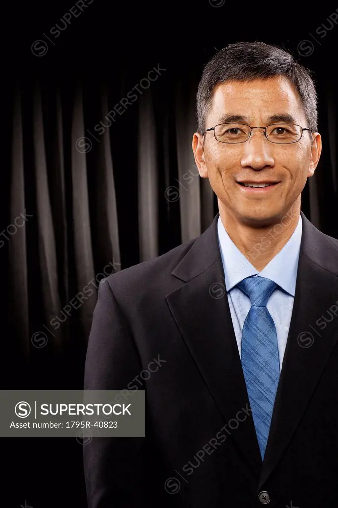 USA, Utah, Provo, Portrait of businessman standing in front of black curtain