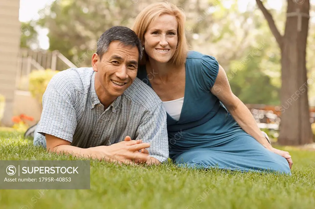 USA, Utah, Provo, Portrait of smiling mature couple sitting on lawn in garden