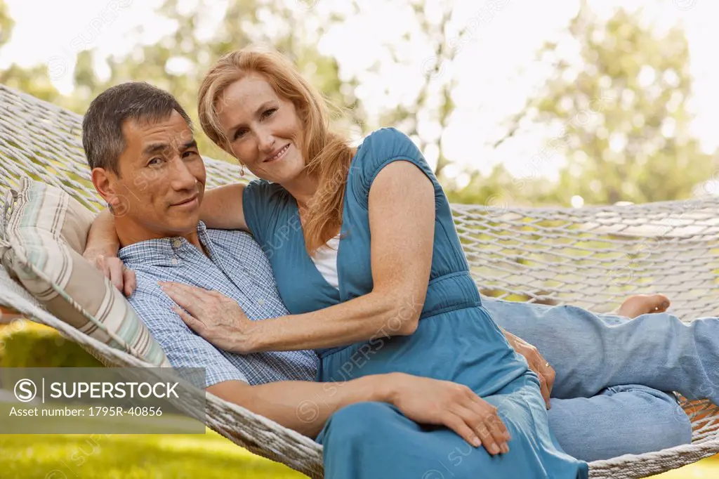 USA, Utah, Provo, Portrait of smiling mature couple relaxing in hammock in garden