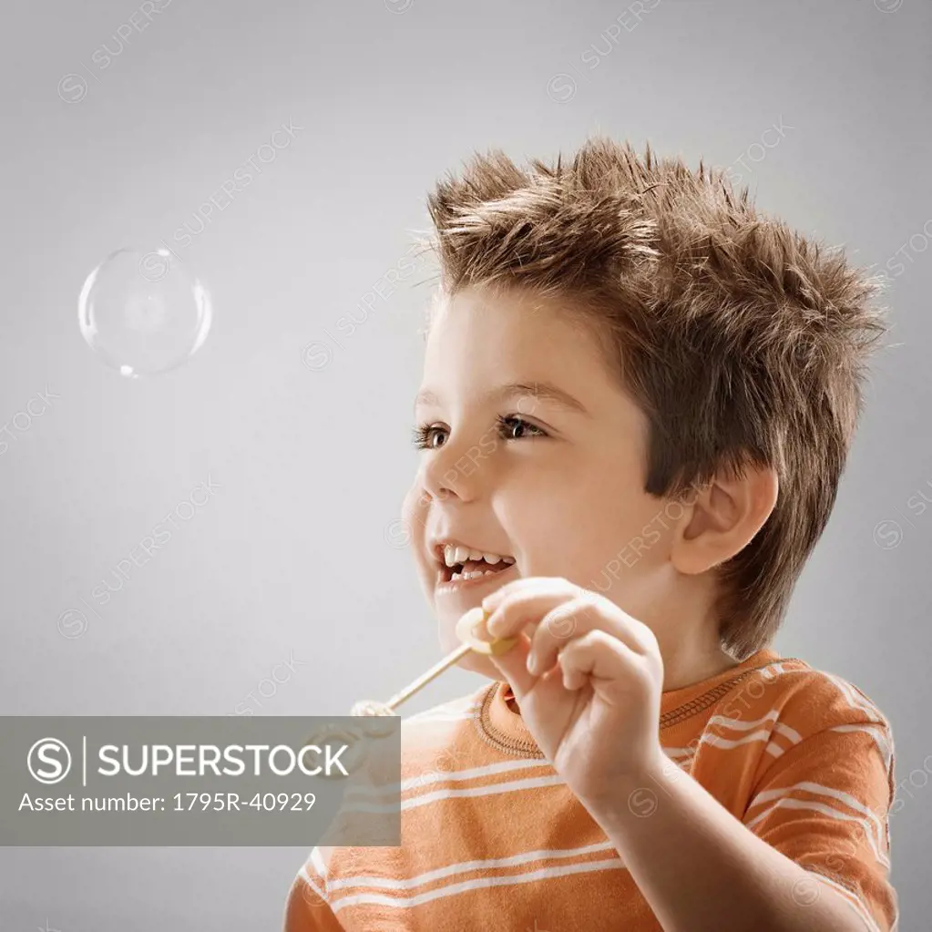 Studio portrait of boy 8_9 blowing bubbles