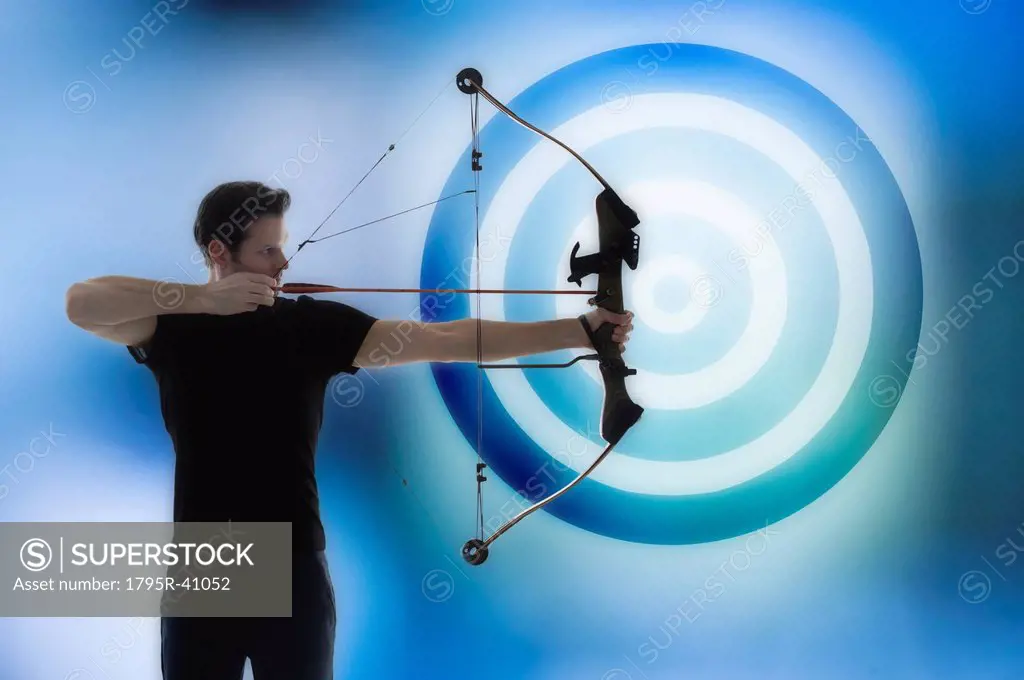 Man holding bow and aiming with blue circle in background