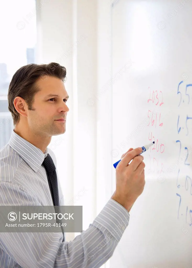 Businessman writing on whiteboard