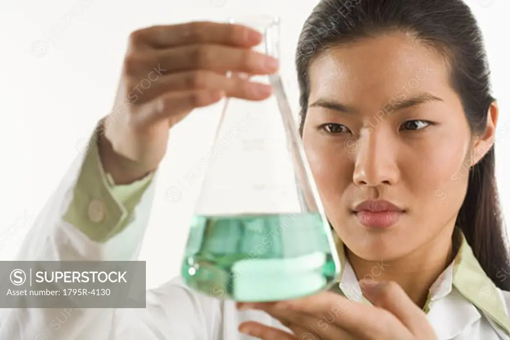 Scientist looking at glass beaker