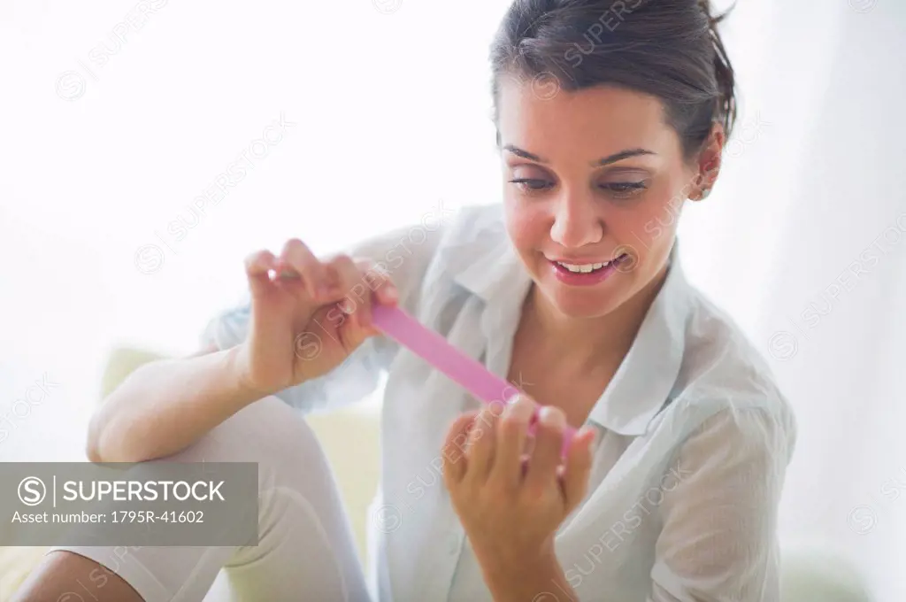 Attractive young woman filing nails