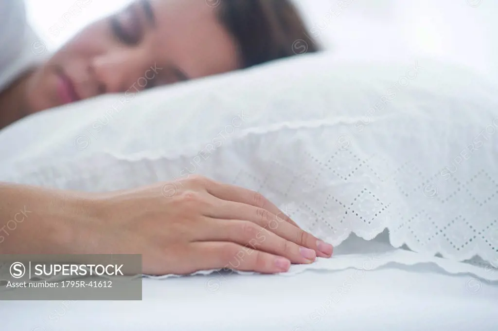 Happy young woman sleeping in bed