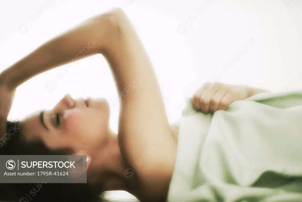 Profile of young woman lying in bed