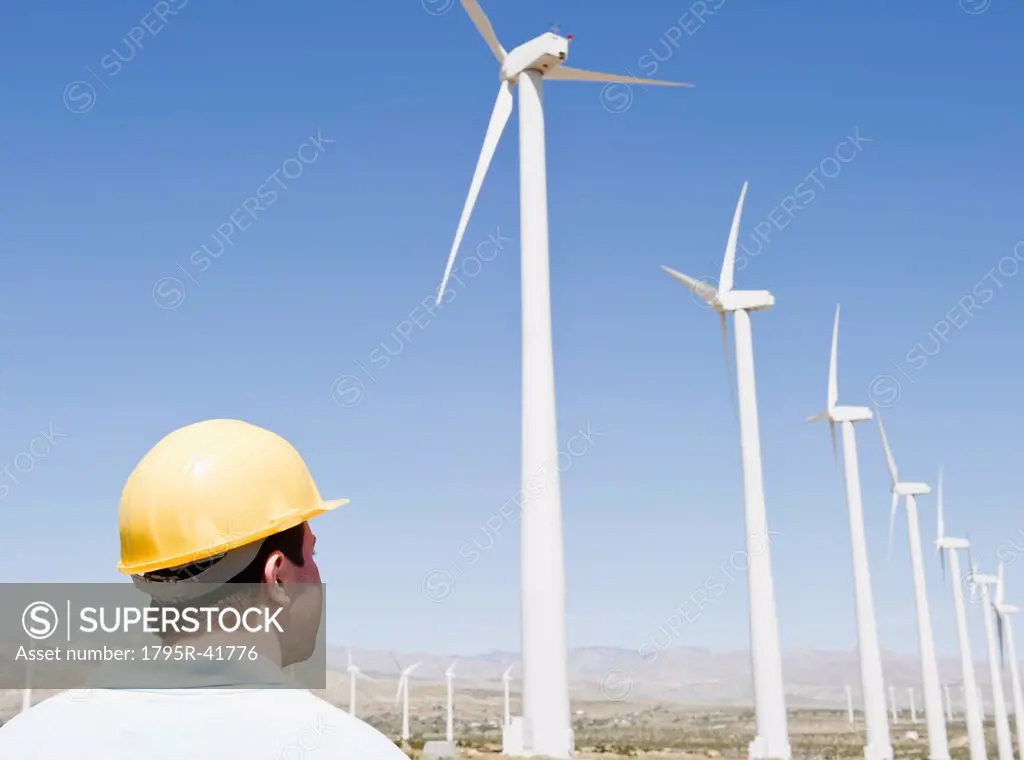 USA, California, Palm Springs, Coachella Valley, San Gorgonio Pass, Man in hard hat looking at wind turbines