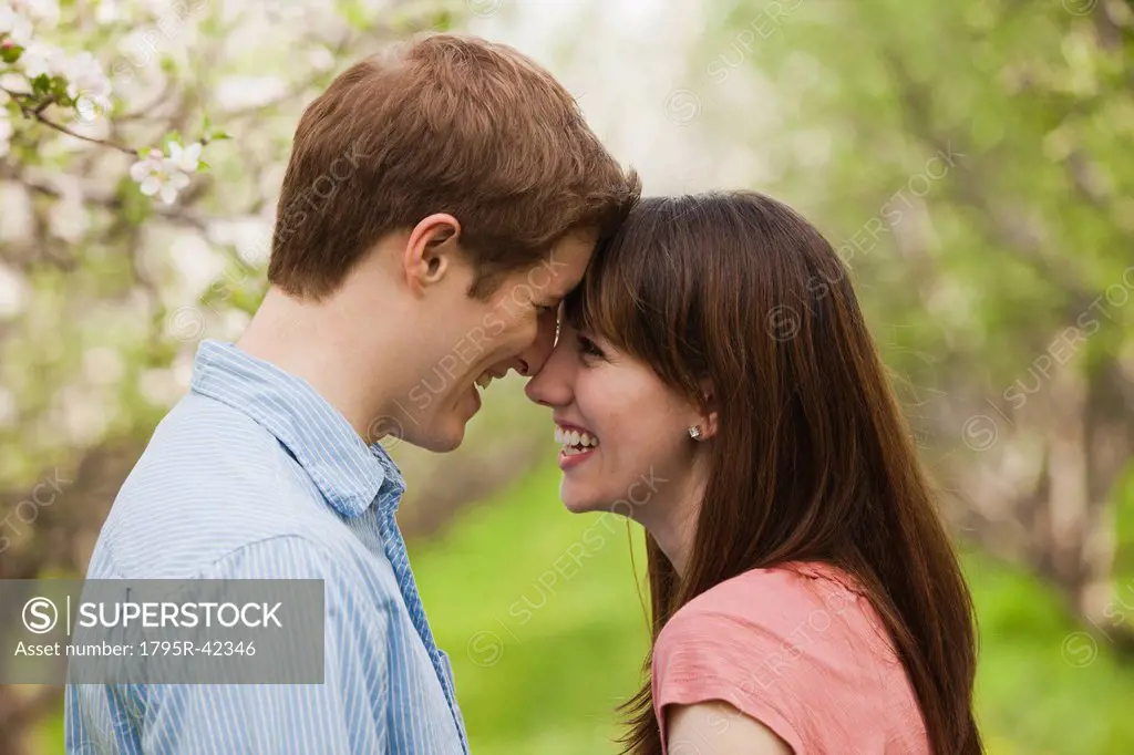 USA, Utah, Provo, Young couple face to face in orchard