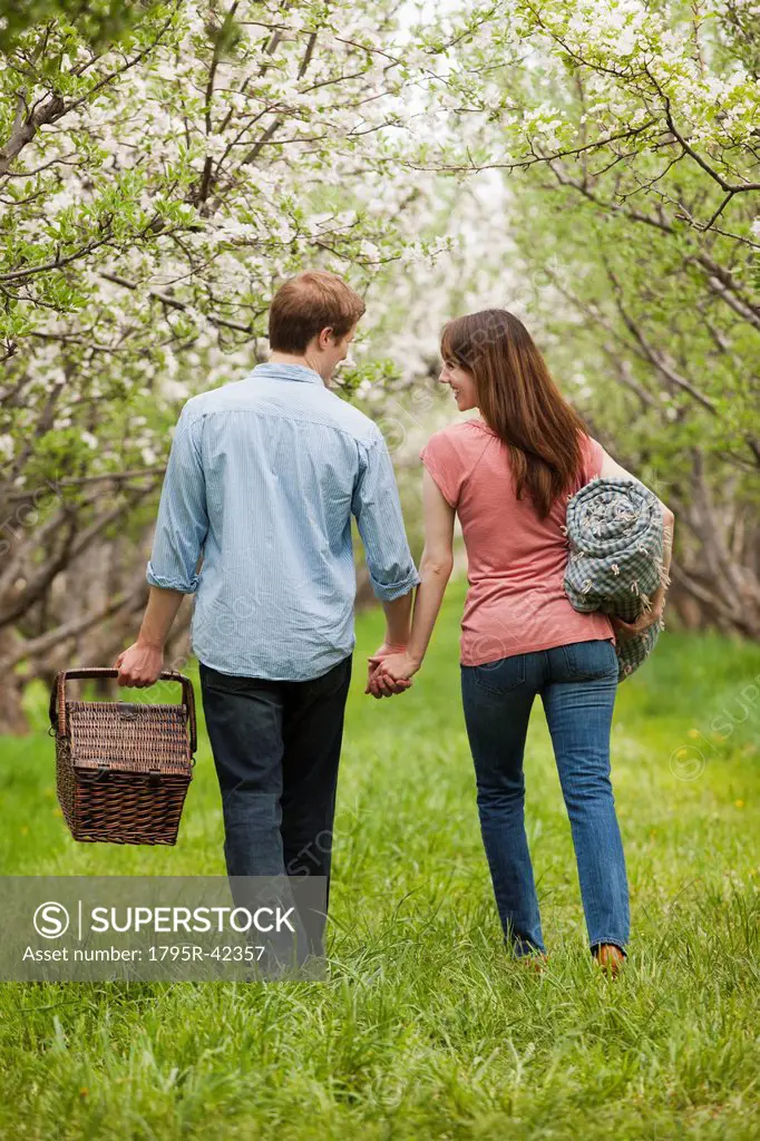 USA, Utah, Provo, Young couple with picnic basket in orchard