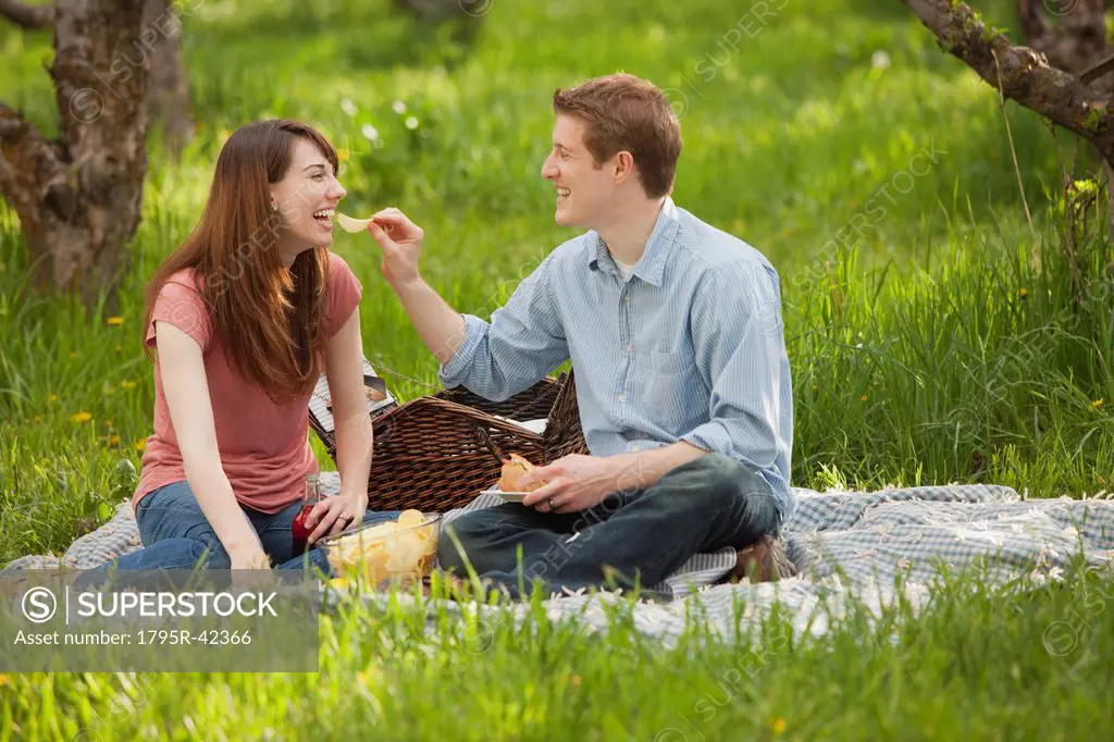 USA, Utah, Provo, Young couple having picnic in orchard