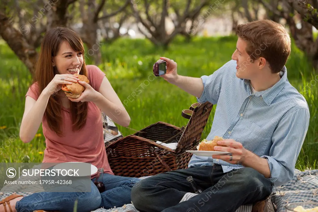 USA, Utah, Provo, Young couple having picnic in orchard