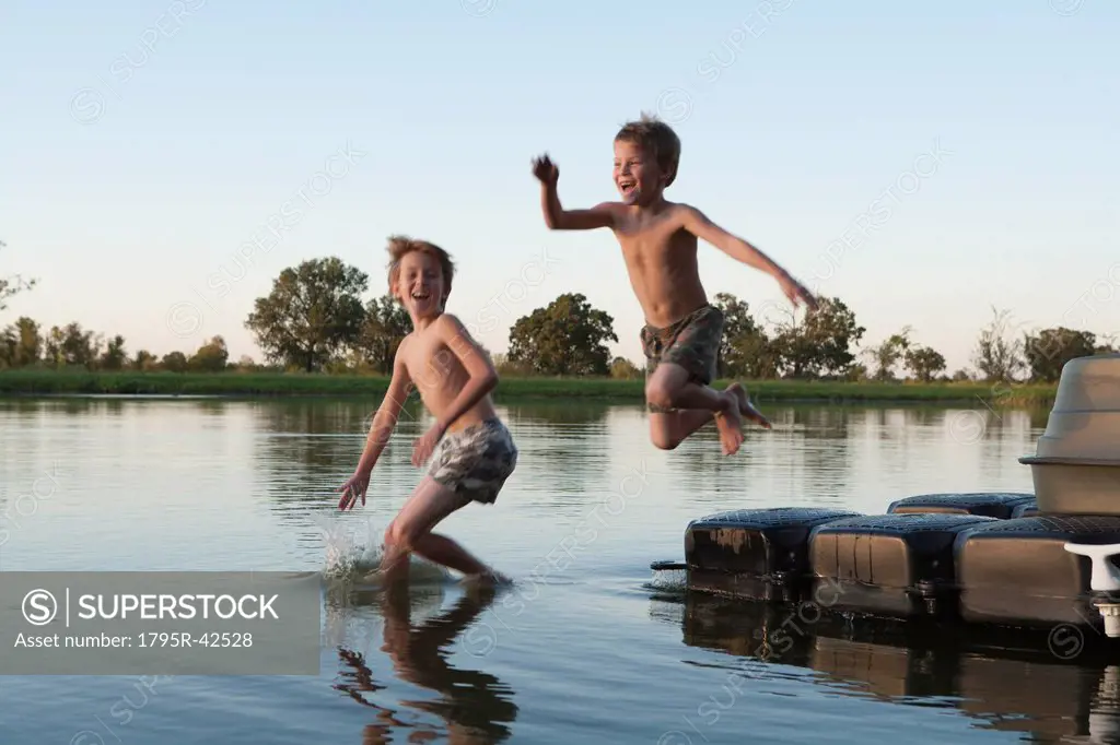 USA, Texas, Texarkana, Two boys 8_9 jumping into lake