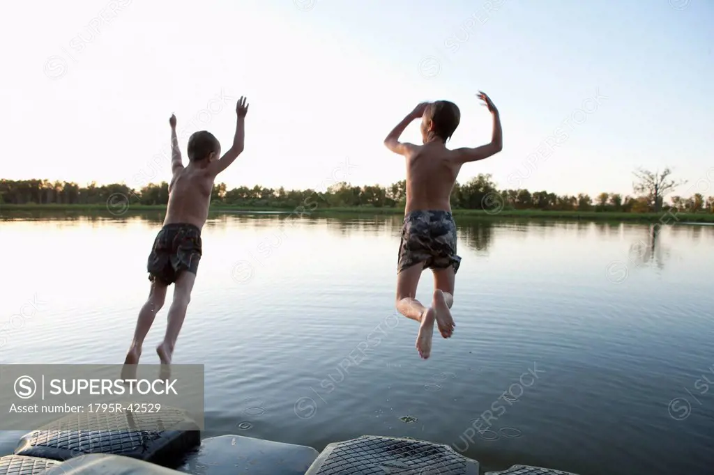 USA, Texas, Texarkana, Two boys 8_9 jumping into lake