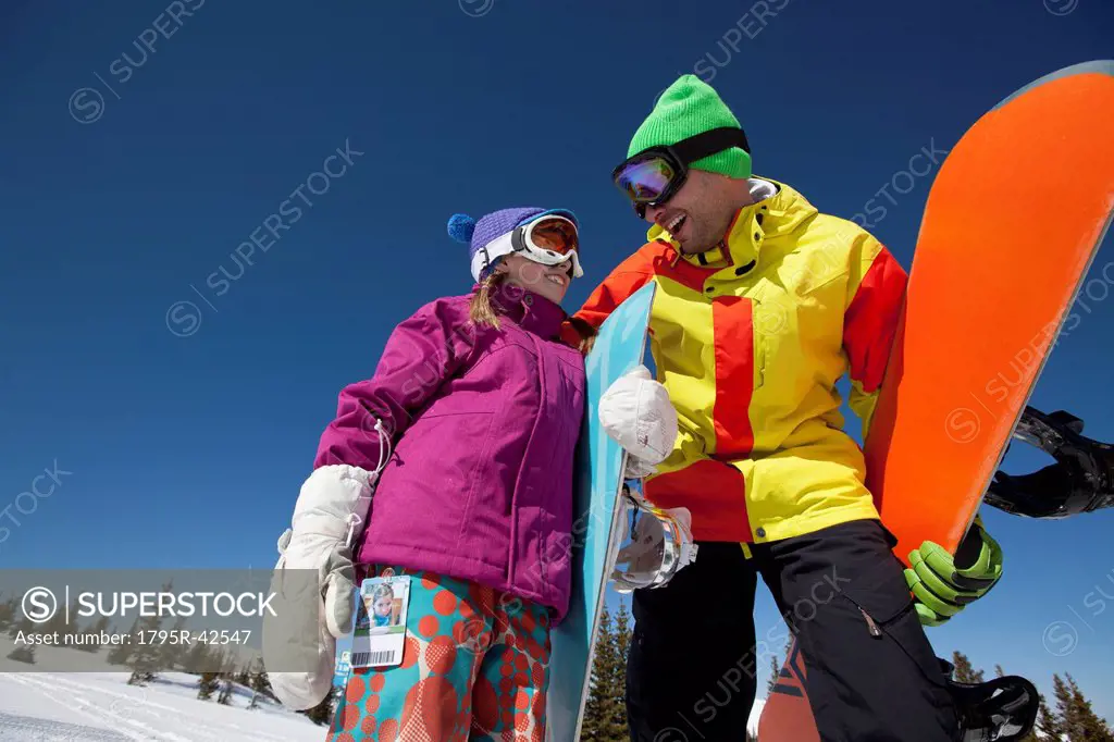 USA, Colorado, Telluride, Father and daughter 10_11 posing with snowboards in winter scenery