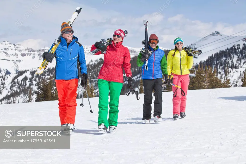 USA, Colorado, Telluride, Family with adult offspring walking in winter scenery carrying ski