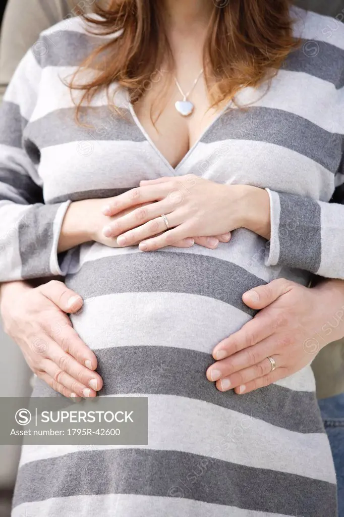 Man´s hands on pregnant woman´s belly