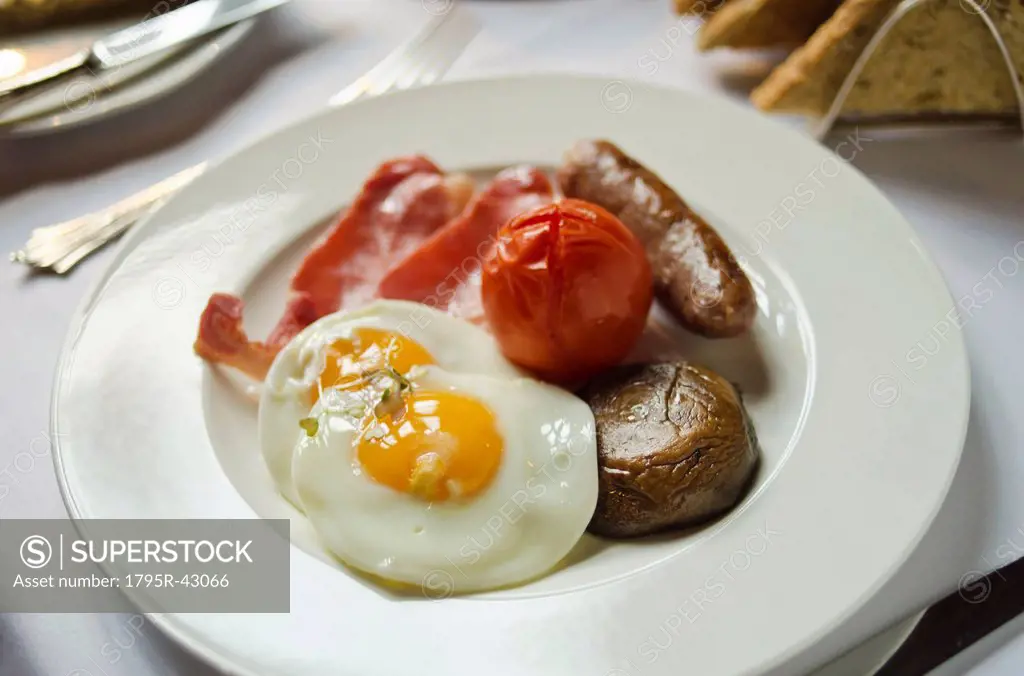 Plate with English breakfast on table