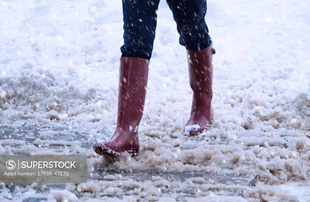 USA, New York, New York City, close up of woman´s legs walking in winter slush