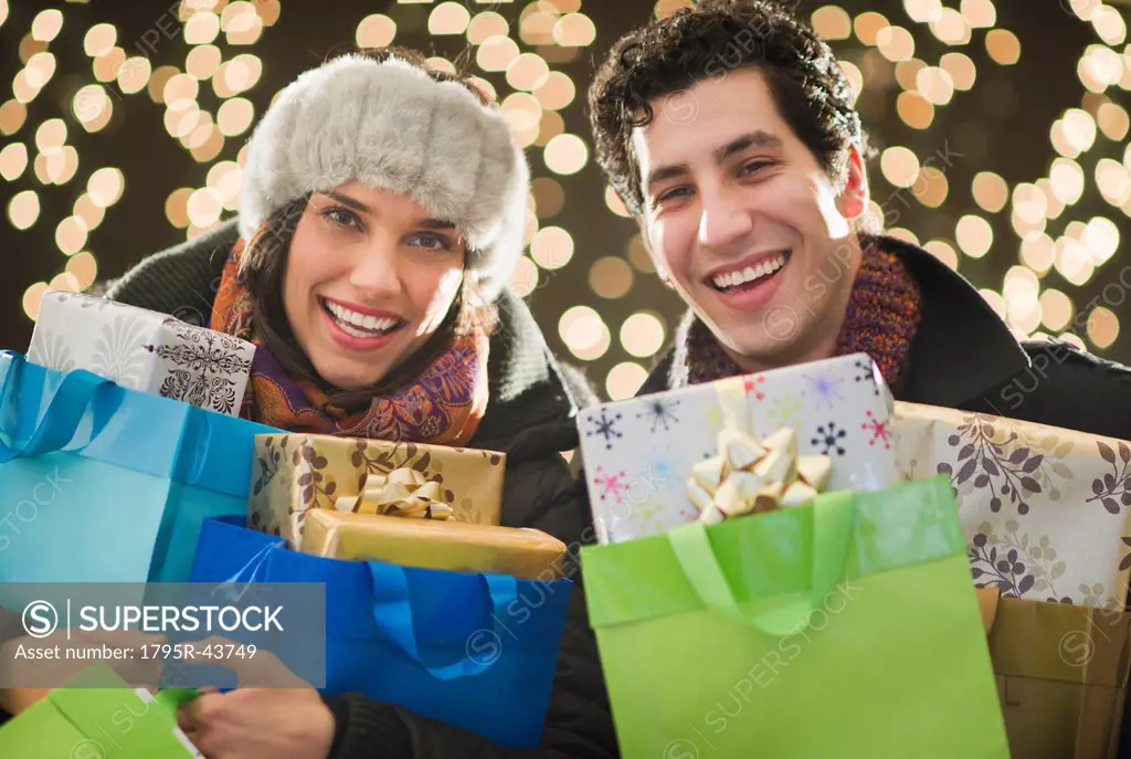 Happy couple holding Christmas presents
