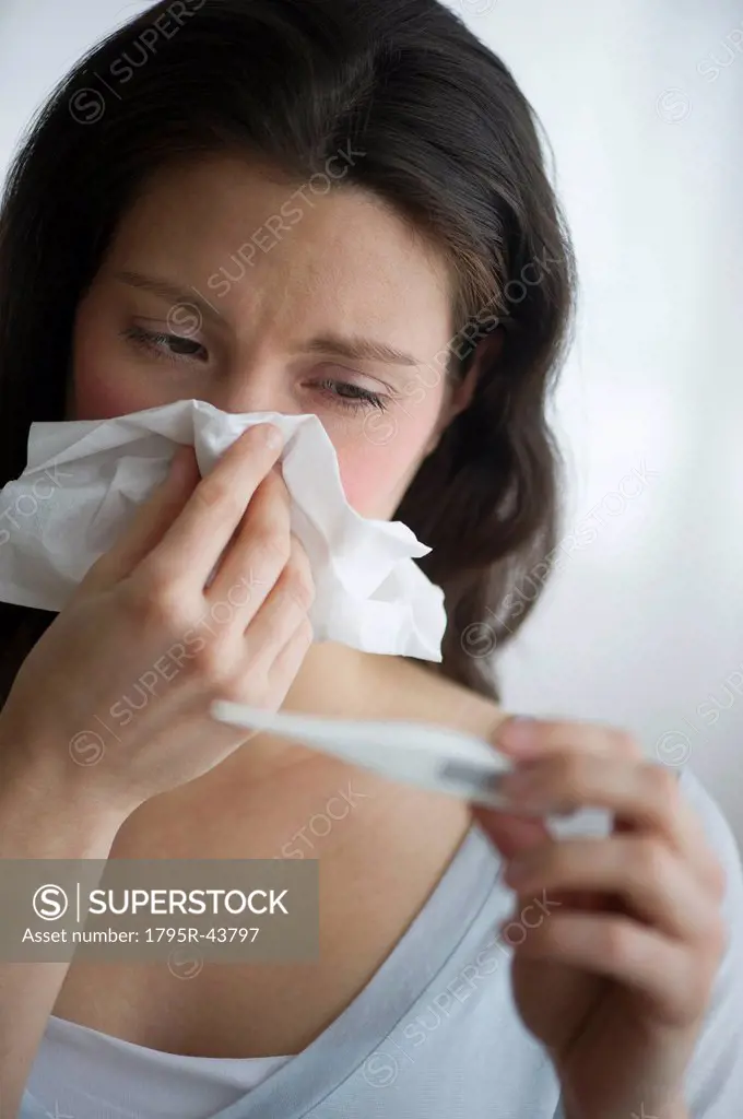 Woman with flu blowing nose