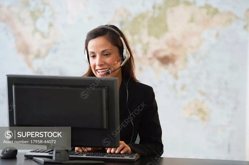 USA, New Jersey, Jersey City, female customer service representative with headset working on computer