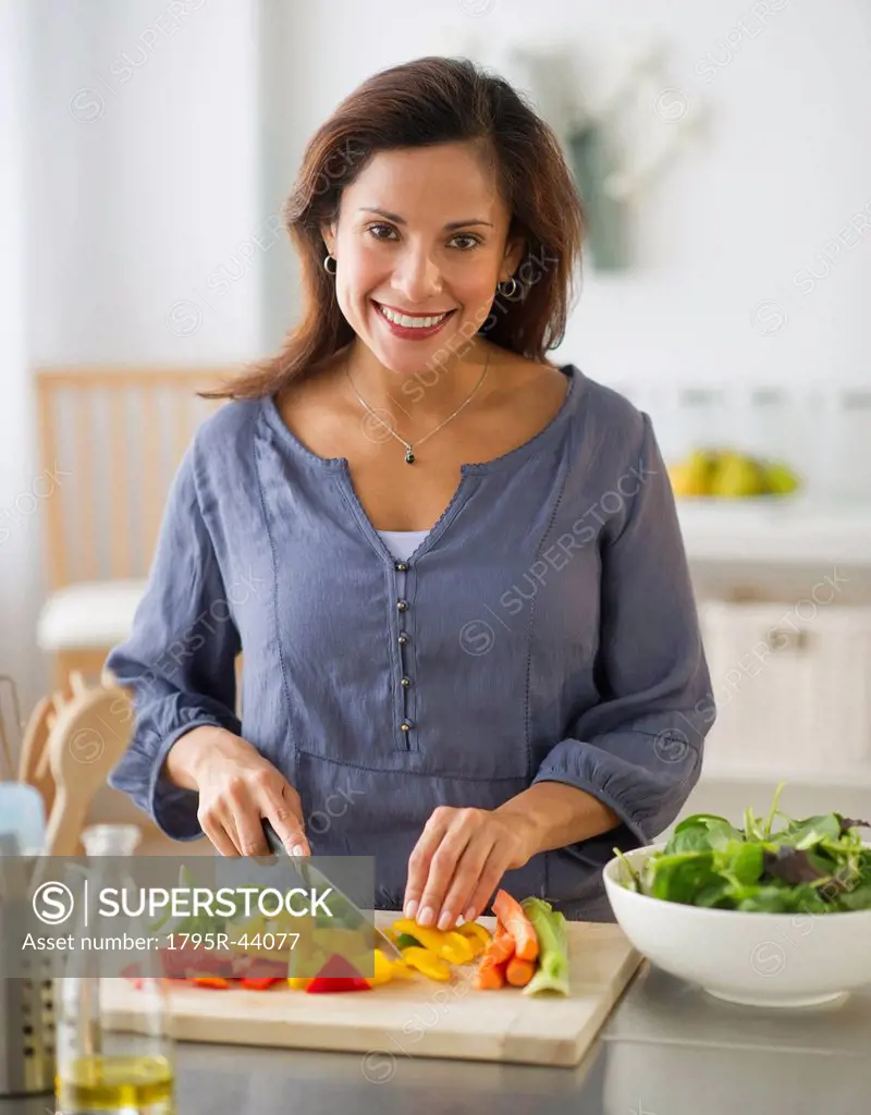 USA, New Jersey, Jersey City, smiling woman preparing food in kitchen