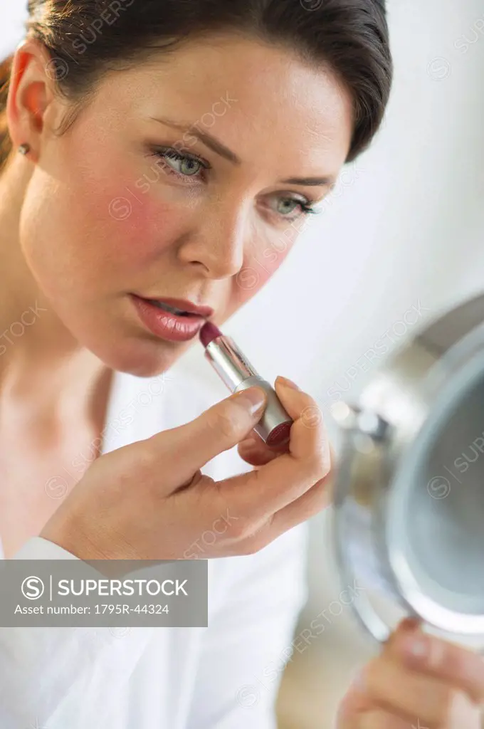 USA, New Jersey, Jersey City, woman applying lipstick