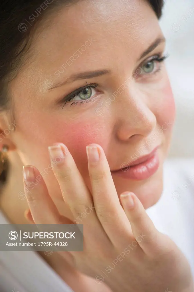 USA, New Jersey, Jersey City, woman applying cosmetics on face
