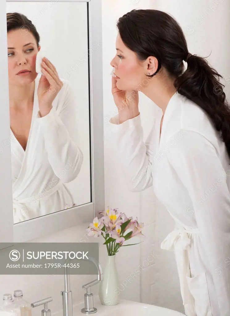 USA, New Jersey, Jersey City, woman removing make_up in bathroom