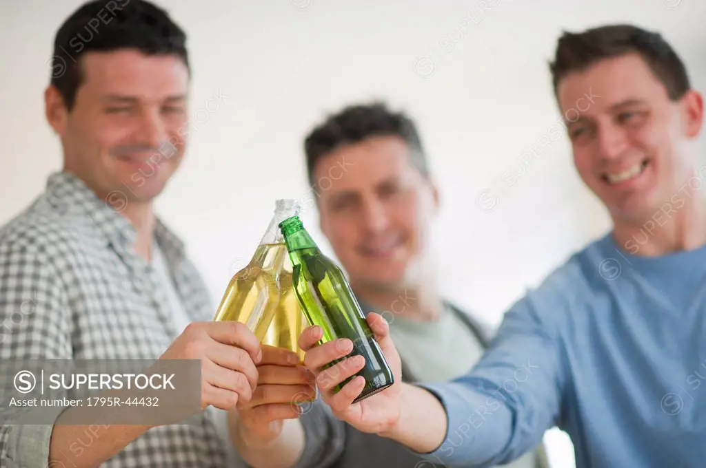USA, New Jersey, Jersey City, three men toasting with beer