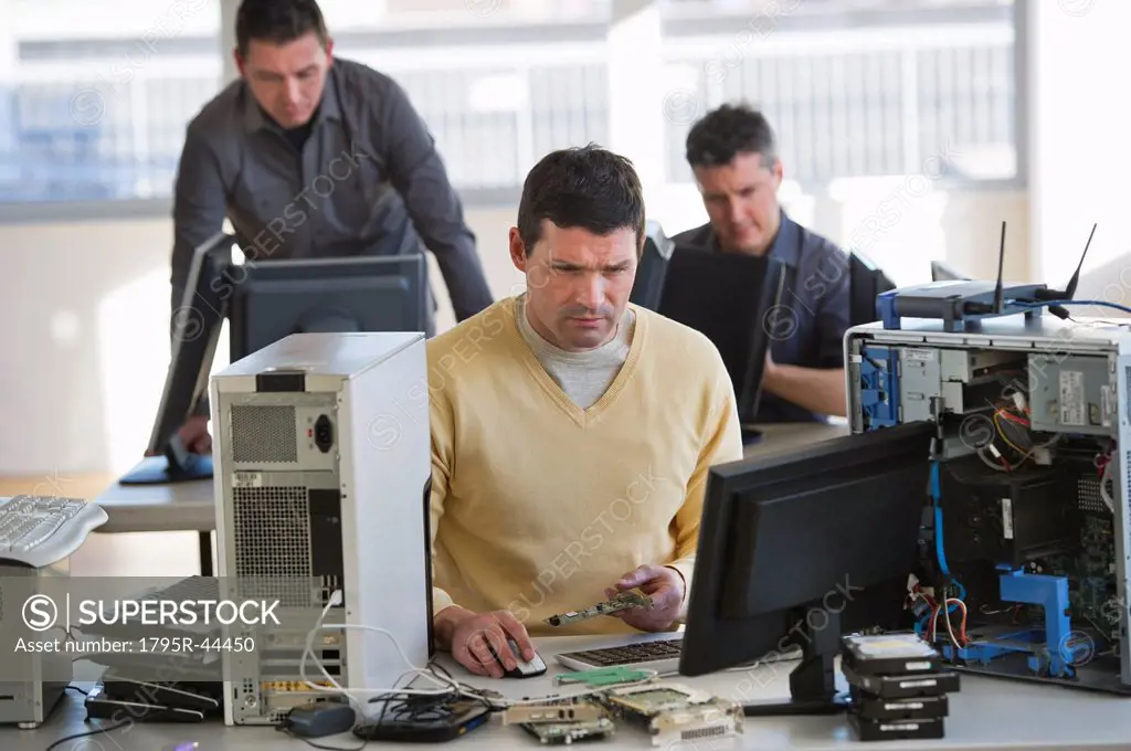 USA, New Jersey, Jersey City, IT Professionals repairing computer in office